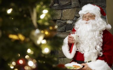Santa Claus Holding Milk And Cookies By Christmas Tree