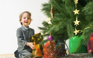 Happy Boy Opening Christmas Gift Under Tree