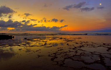 夏威夷平坦礁石海岸的金色夕阳与月色