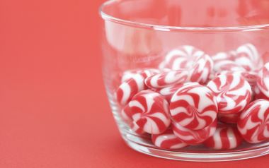 Red Background Glass Bowl Swirl Peppermint Candy Closeup