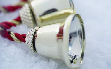 冬日雪景中的红色丝带金色圣诞铃铛特写