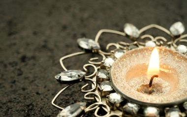 Macro Closeup Of Burning Tealight Candle And Vintage Jewelry