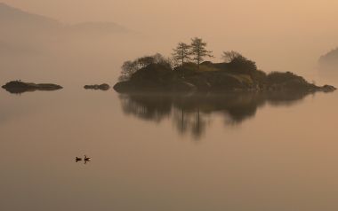 清晨薄雾笼罩的湖心小岛宁静湖景