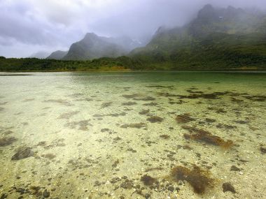 挪威罗弗敦群岛的清澈湖泊与云雾高山