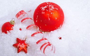 雪中红色圣诞球与丝带特写