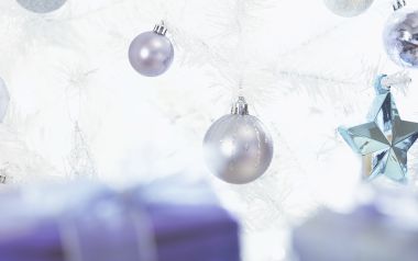 Close Up Of Silver And Blue Ornaments On White Christmas Tree