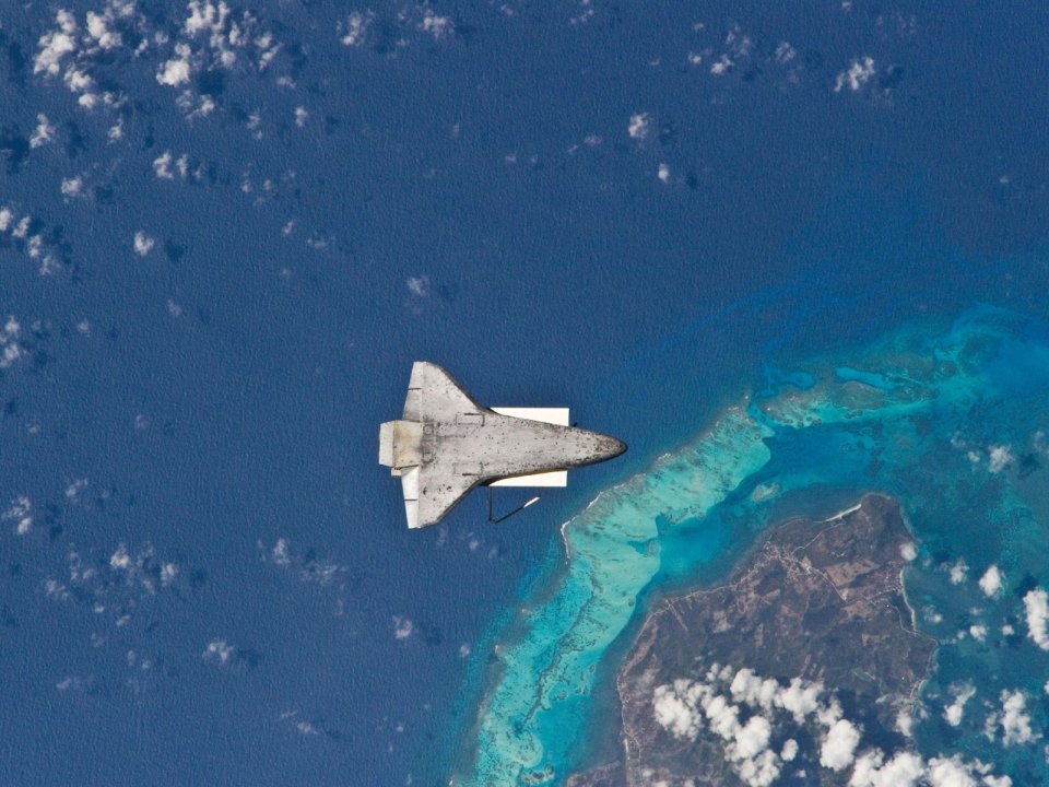 Space Shuttle Flying Over Tropical Island Coral Reef From Iss Perspective