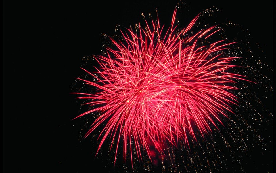 黑色夜空下绽放的红色节日烟花秀