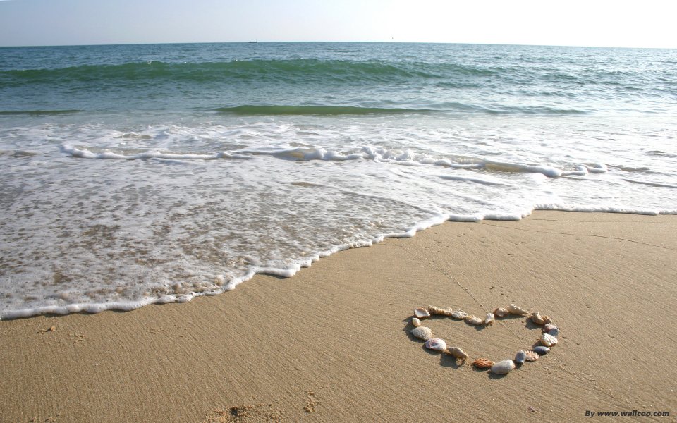 Heart Shape Made Of Shells On Sunny Beach Sea View
