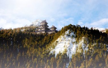 黎明时分雪山森林中的日式城堡奇幻风景