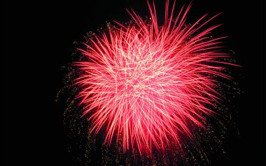 黑色夜空下盛放的红色节日烟花