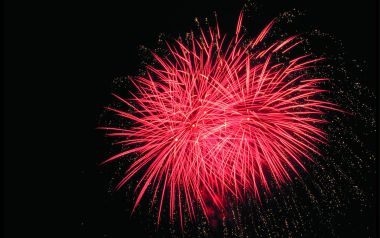 黑色夜空下绽放的红色节日烟花秀