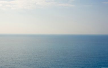 淡蓝晴空下开阔远海水天相接海景