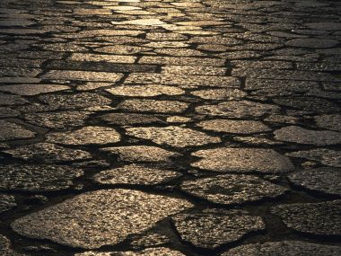 夕阳下泛金色反光的复古石板路特写