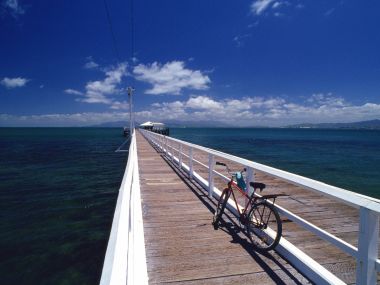 夏日海滨长栈桥停靠红色自行车 碧海蓝天自然风光