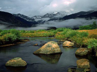 落基山脉雪山脚下溪流晨雾自然风光