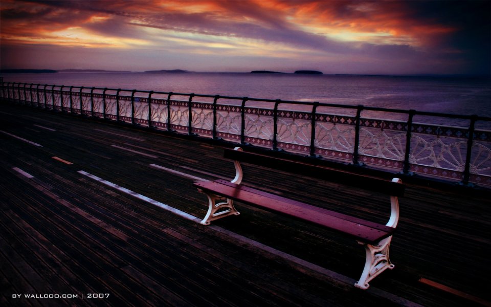 Lonely Bench On Pier At Sunset