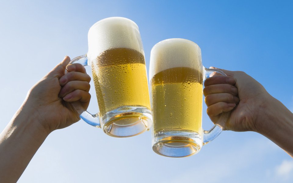 HB042_350A_People_toasting_with_mugs_of_beer_under_blue_sky