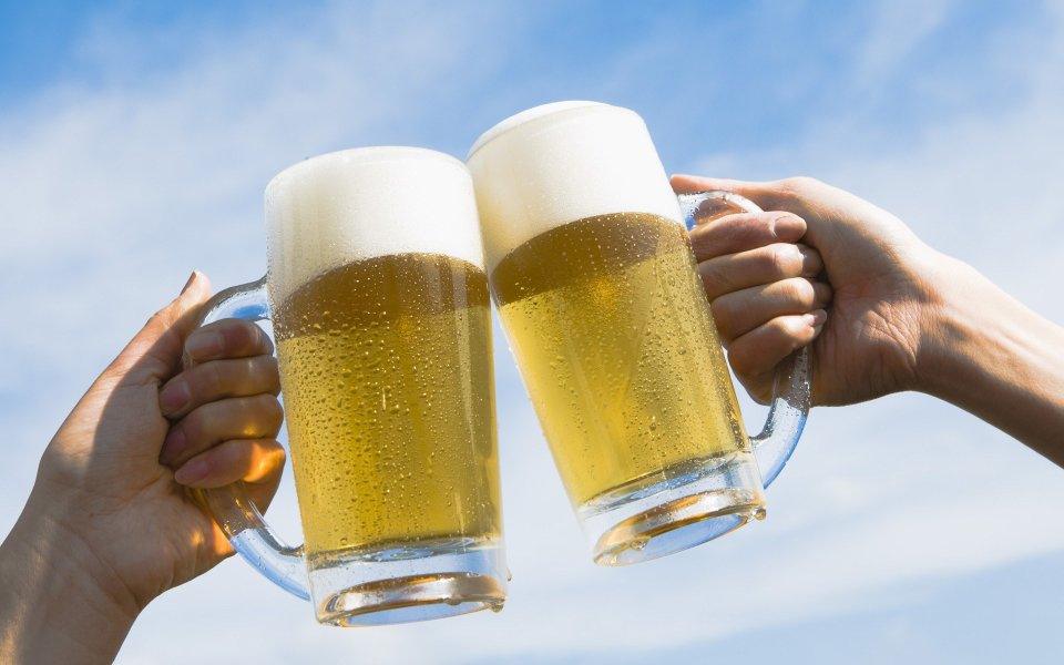 HB043_350A_Two people toasting with beer against blue sky