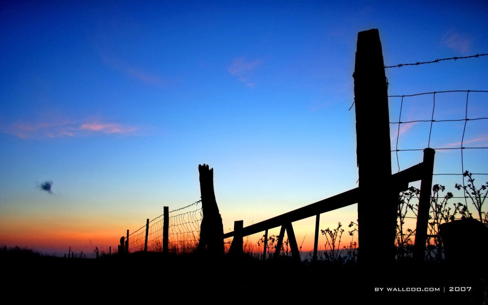 乡村旷野夕阳下的铁丝网剪影