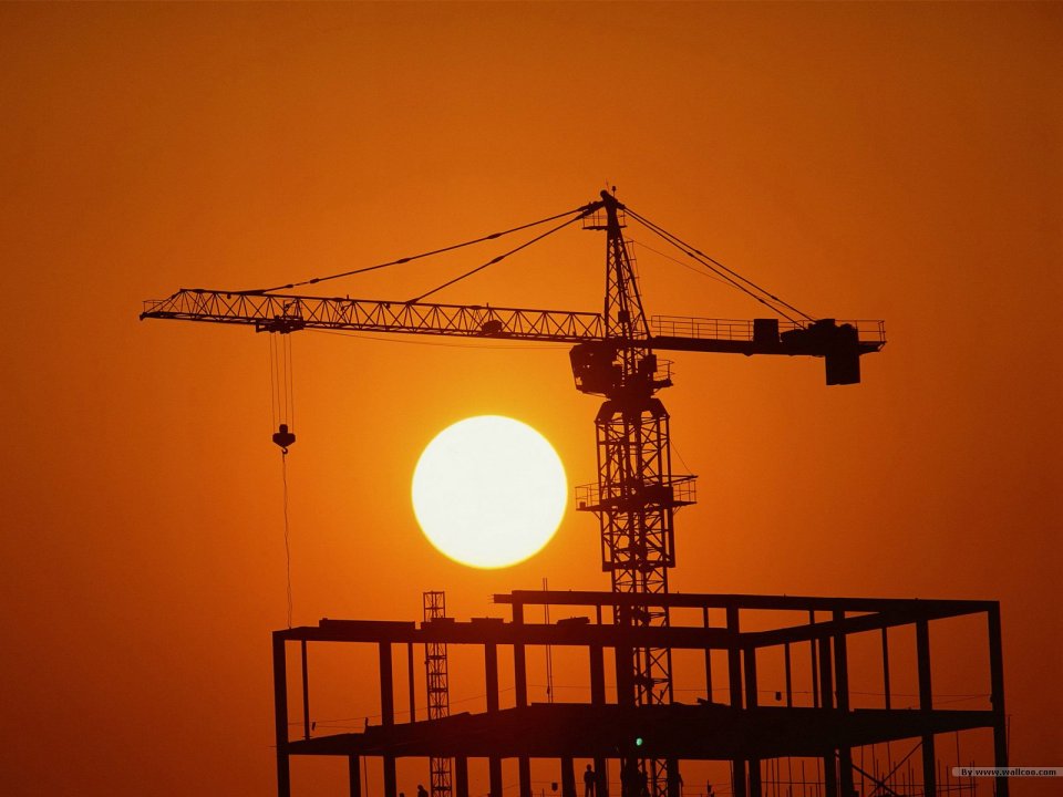 夕阳下的建筑工地塔吊剪影