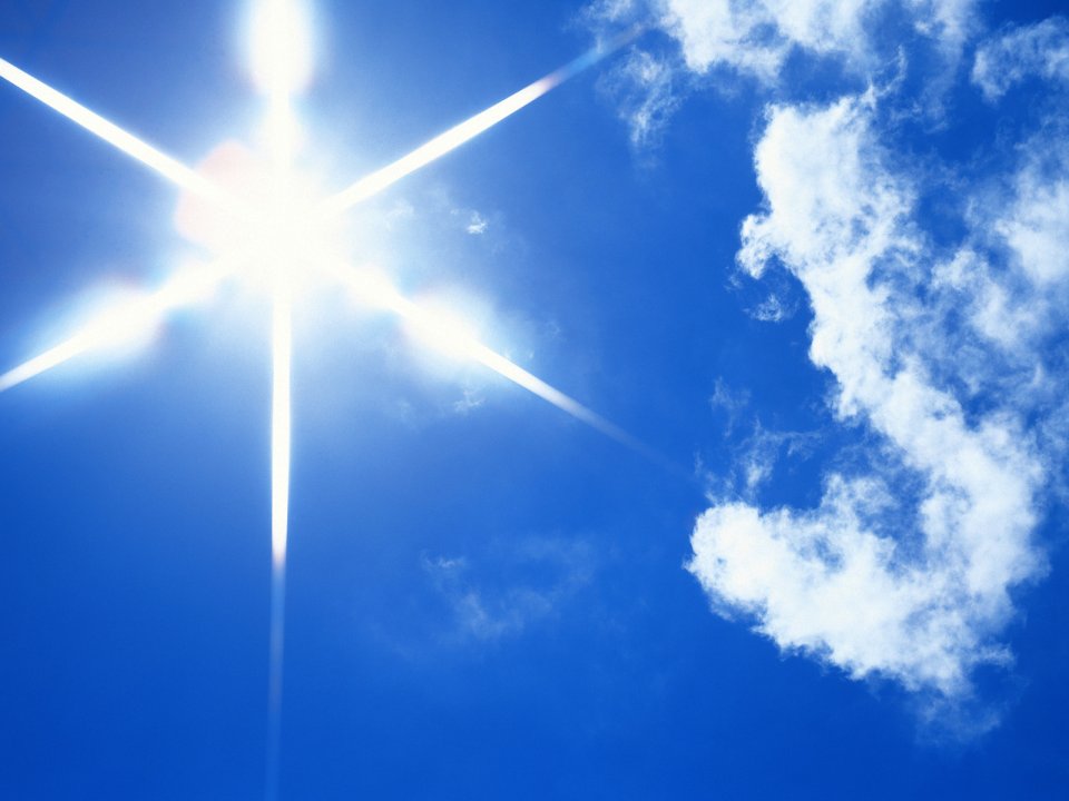 蓝天白云下的耀眼太阳星芒