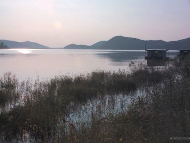 黄昏下的静谧湖泊与水上小屋