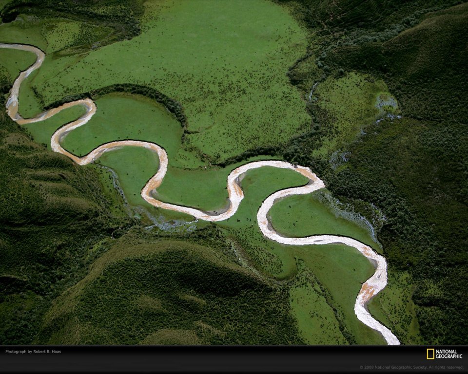 中国绿色山谷中的蜿蜒河流航拍图