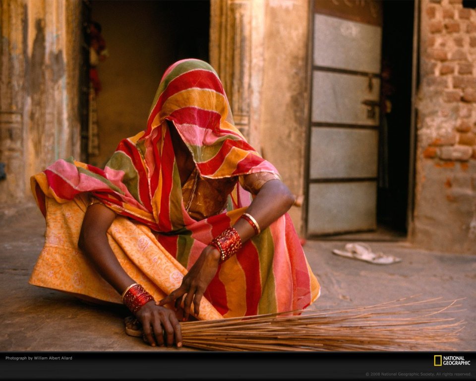 Indian Woman In Striped Saree Sweeping