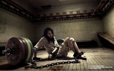 被铁链束缚的女性在体育馆内，象征人权压迫